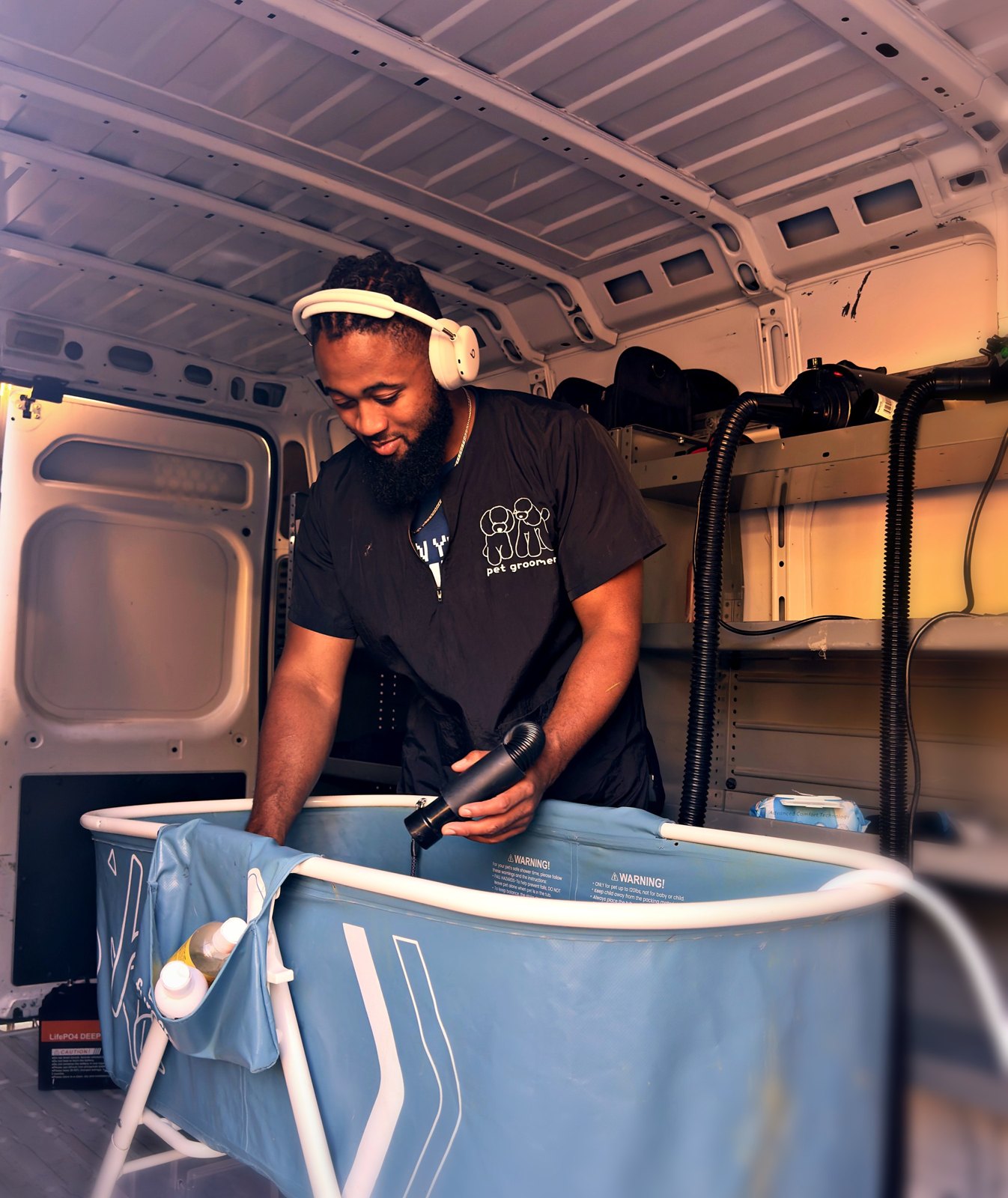 Inside the van: the grooming bay, warm-water tub and supplies, set up before the dog comes in